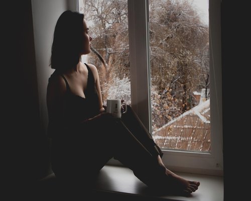 A quiet moment looking out a window in a city apartment